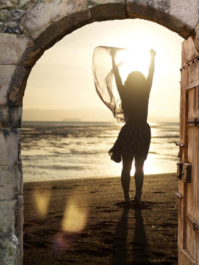 Frau am Strand bei Sonnenuntergang