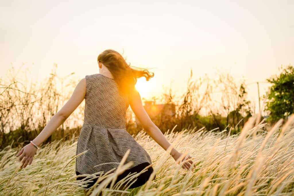 Frau im Sonnenuntergang im Feld